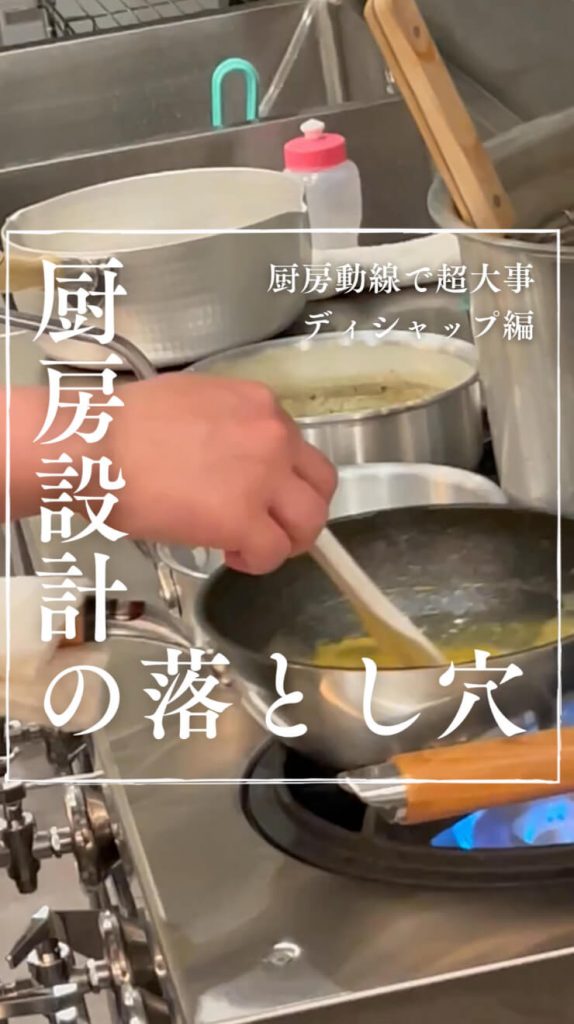 業務用キッチンのクローズアップで、青い炎のコンロで手で食べ物をかき混ぜている様子が写っています。日本語のテキストオーバーレイには、キッチンの設計と食洗機に関連する落とし穴について書かれています。